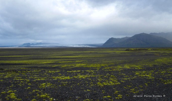 A wide expanse of lava gravel with the glacier Skeiðarárjökull in the background.